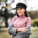 girl in a newsboy cap in a park
