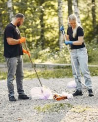 Cleanups couple collects garbage in garbage bags in park