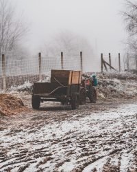 snowy field with a wagon attached to a four wheel motorcycle